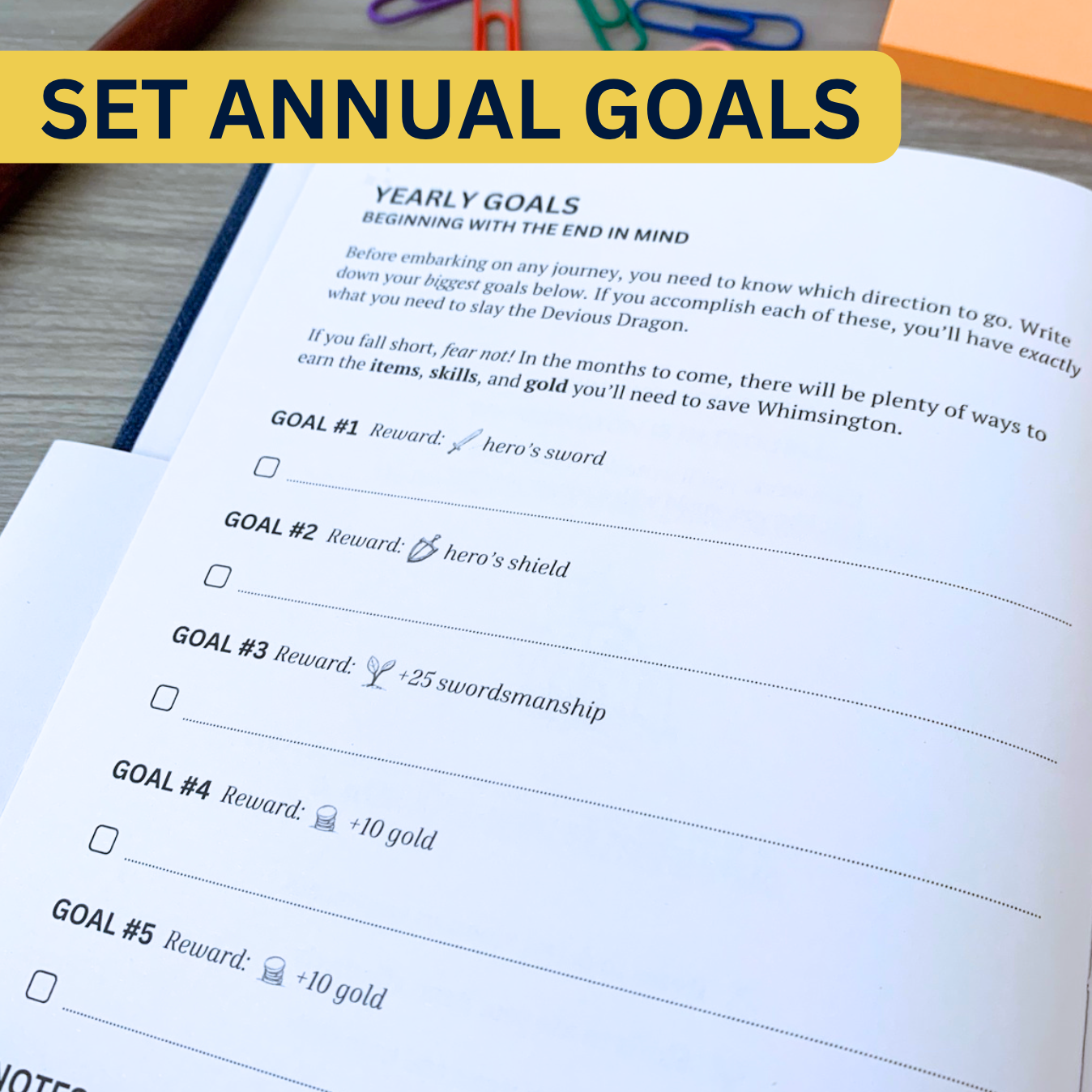 Open planner page with a section for setting yearly goals, each offering rewards like a hero's sword or shield. The label reads, Set Annual Goals.